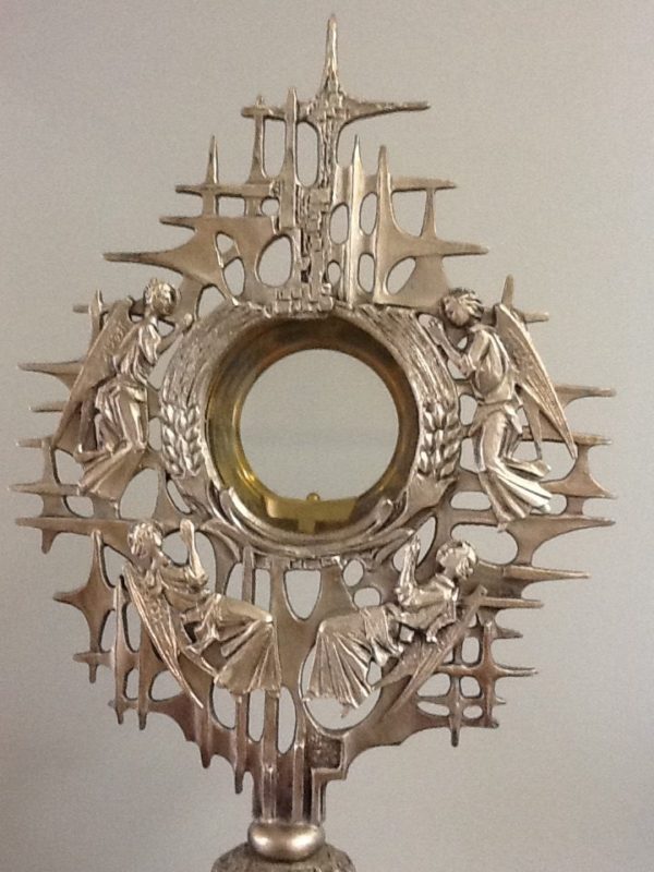 Ostensorio realizzato a mano in metallo da artista italiano decorato con 4 angeli in rilievo e alla base pesce pezzo unico cm.23 x 45 h. Diametro base cm.13.5