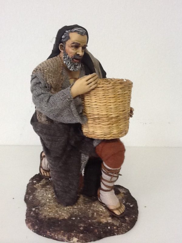Pastore che offre il grano in ginocchio con cesta in mano.in resina con vestiti in stoffa.cm.30